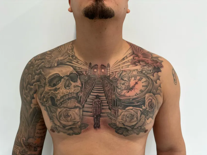 Black and grey chest tattoo of a figure climbing a stairway between two skulls, a clock and roses