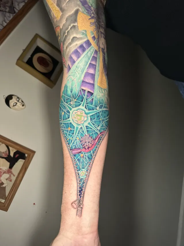 Surreal color forearm tattoo where a zipper opens into a blue stairway scene