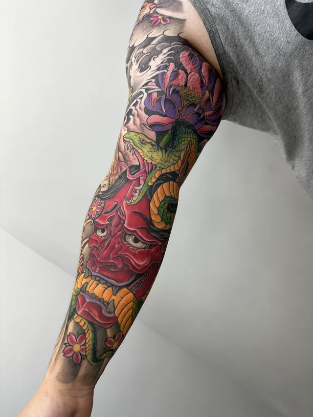 Neo-Oriental full sleeve with a red hannya mask, purple peony, and a green serpent