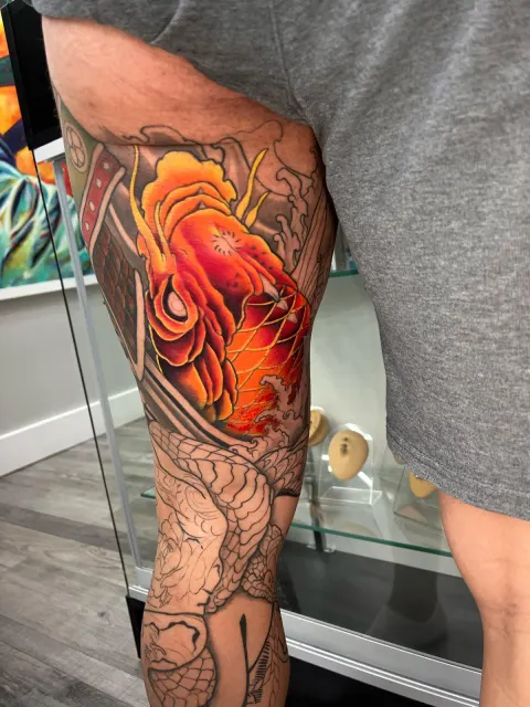 Full-leg neo-oriental tattoo pairing an orange koi with a scaled serpent coiling down the calf