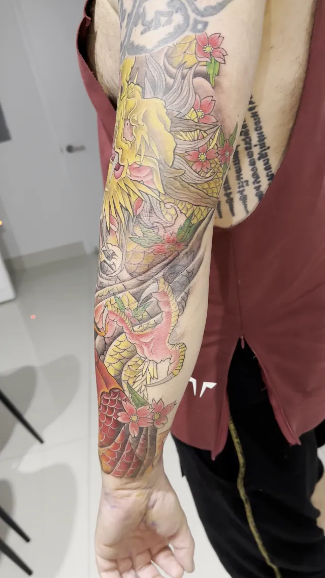 Neo-Oriental full sleeve with a golden dragon, cherry blossoms, and a red koi wrapping the forearm