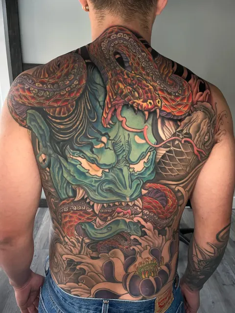 Full-back neo-oriental tattoo of a green oni flanked by serpents, covering shoulders to waist