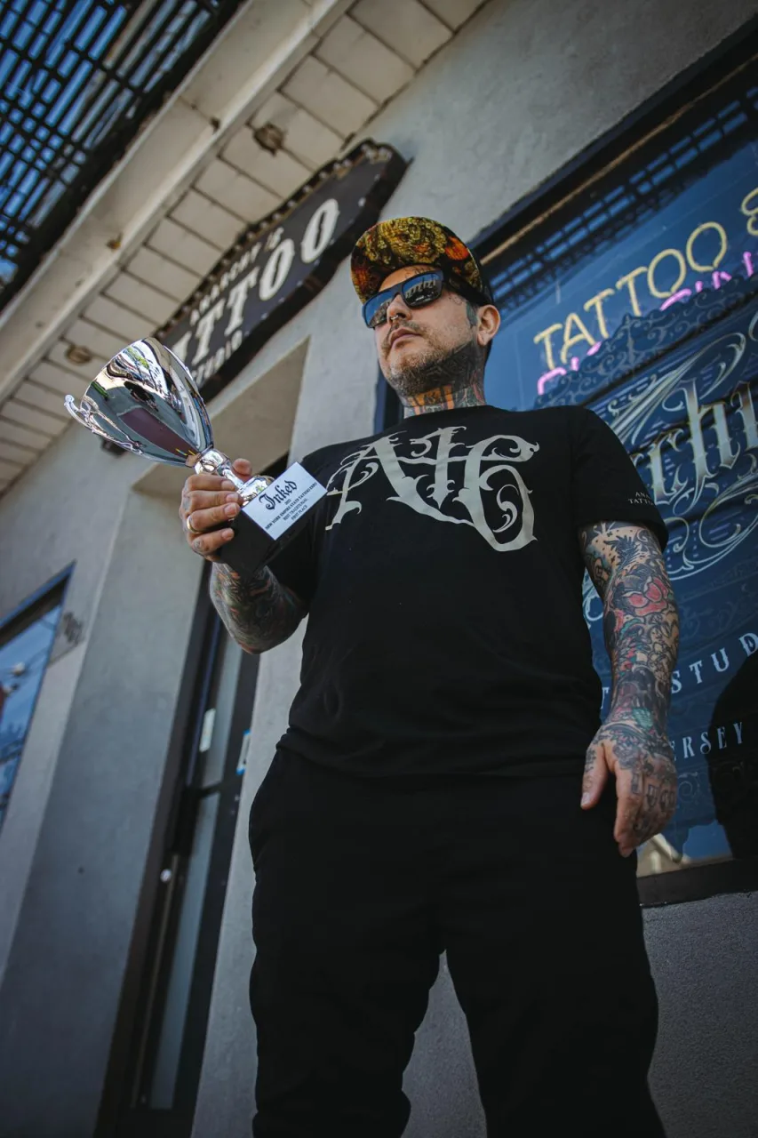Dymon Jimenez holding the 2022 trophy in front of the studio